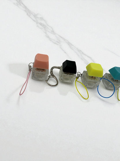 Sensitive Little Souls keyboard fidget clicker toy in peach, black, yellow, and teal with lanyards. Stress relief toy.