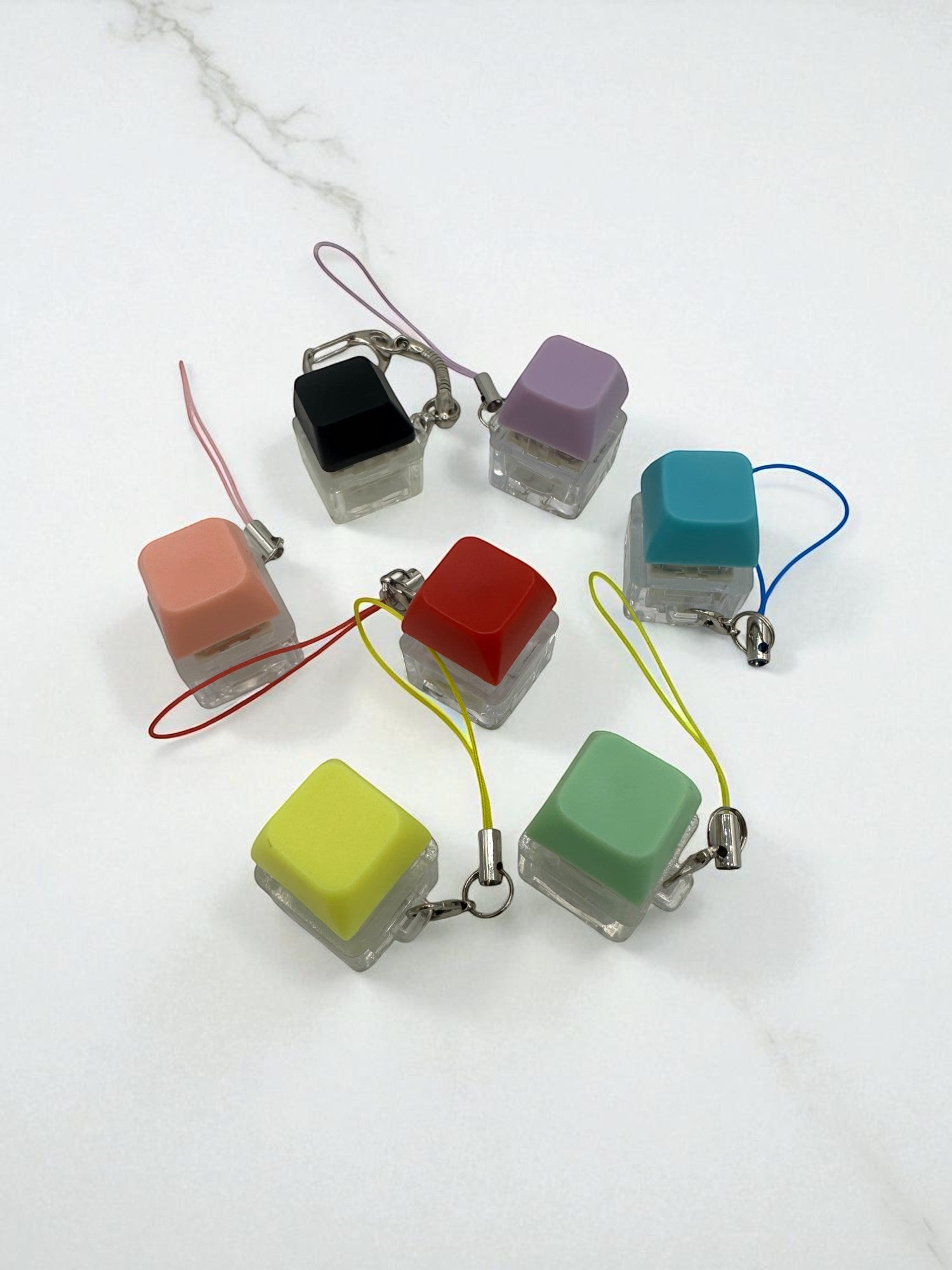 Sensitive Little Souls keyboard fidget clicker toys in various colors: black, peach, red, yellow, purple, teal, and green. Each has a clear base and a lanyard.