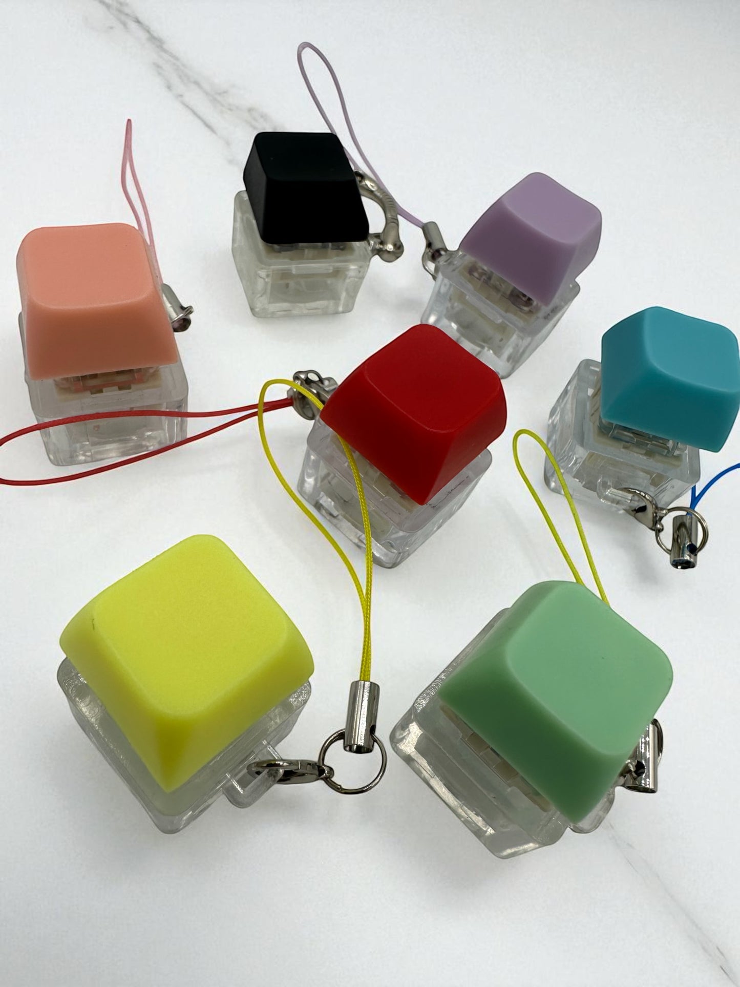 Sensitive Little Souls keyboard fidget clicker toy in various colors: pink, black, purple, red, teal, yellow, and green. Each toy has a clear base and a colorful keycap.