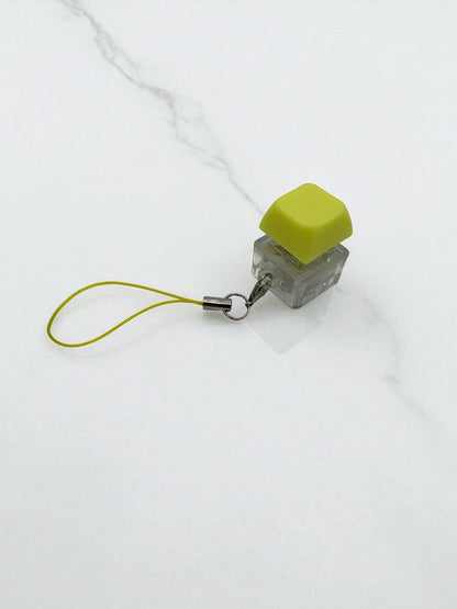 Sensitive Little Souls lime green keyboard key fidget toy with clear base and lanyard for stress relief.