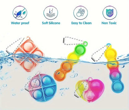 Sensitive Little Souls vibrant silicone bubble popping fidget toys in heart, square, and pea pod shapes, attached to keychains, submerged in water.