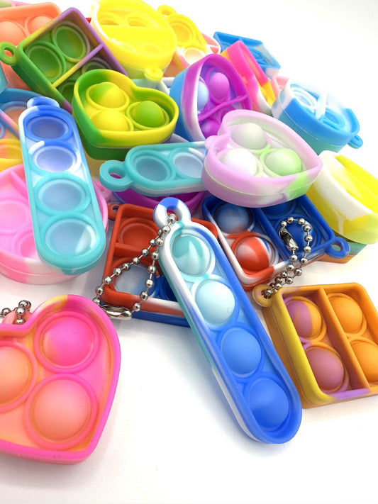 Sensitive Little Souls vibrant silicone bubble popping fidget toys in heart, square, and pea pod shapes with keychain attachments.