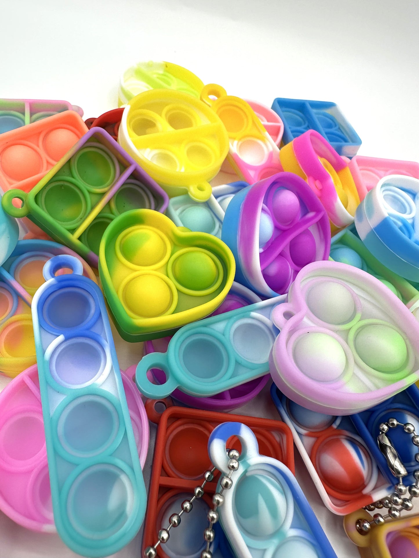 Sensitive Little Souls vibrant silicone bubble popping fidget toys in heart, square, and oval shapes. Assorted bright colors.