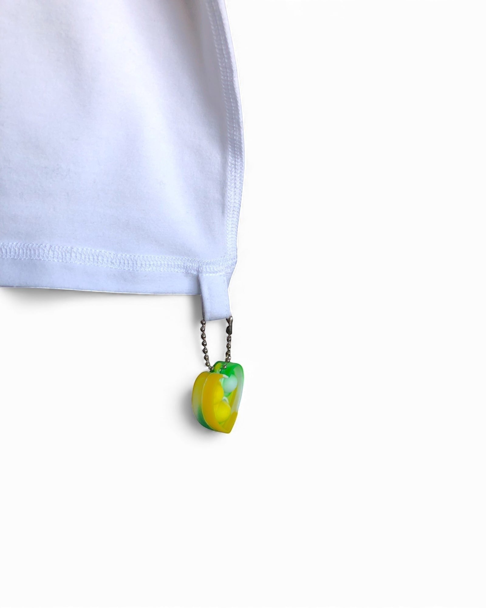 Sensitive Little Souls white adaptive t-shirt with flat seams and a green and yellow fidget loop on the hem.