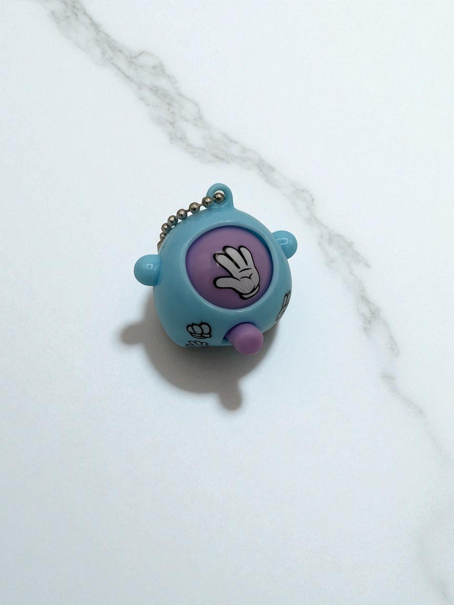 Sensitive Little Souls blue plastic Rock-Paper-Scissors sensory toy with keychain, featuring a purple button and a hand gesture.