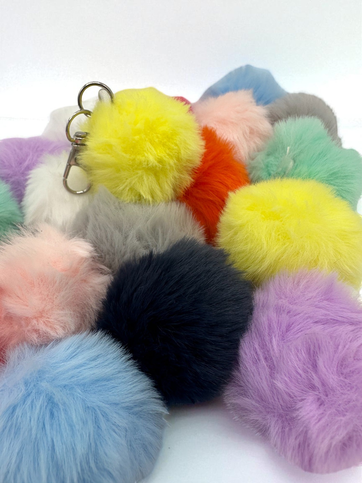 Sensitive Little Souls assorted color plush pom pom keychains. Soft, fluffy, and fuzzy sensory balls with metal keyrings.