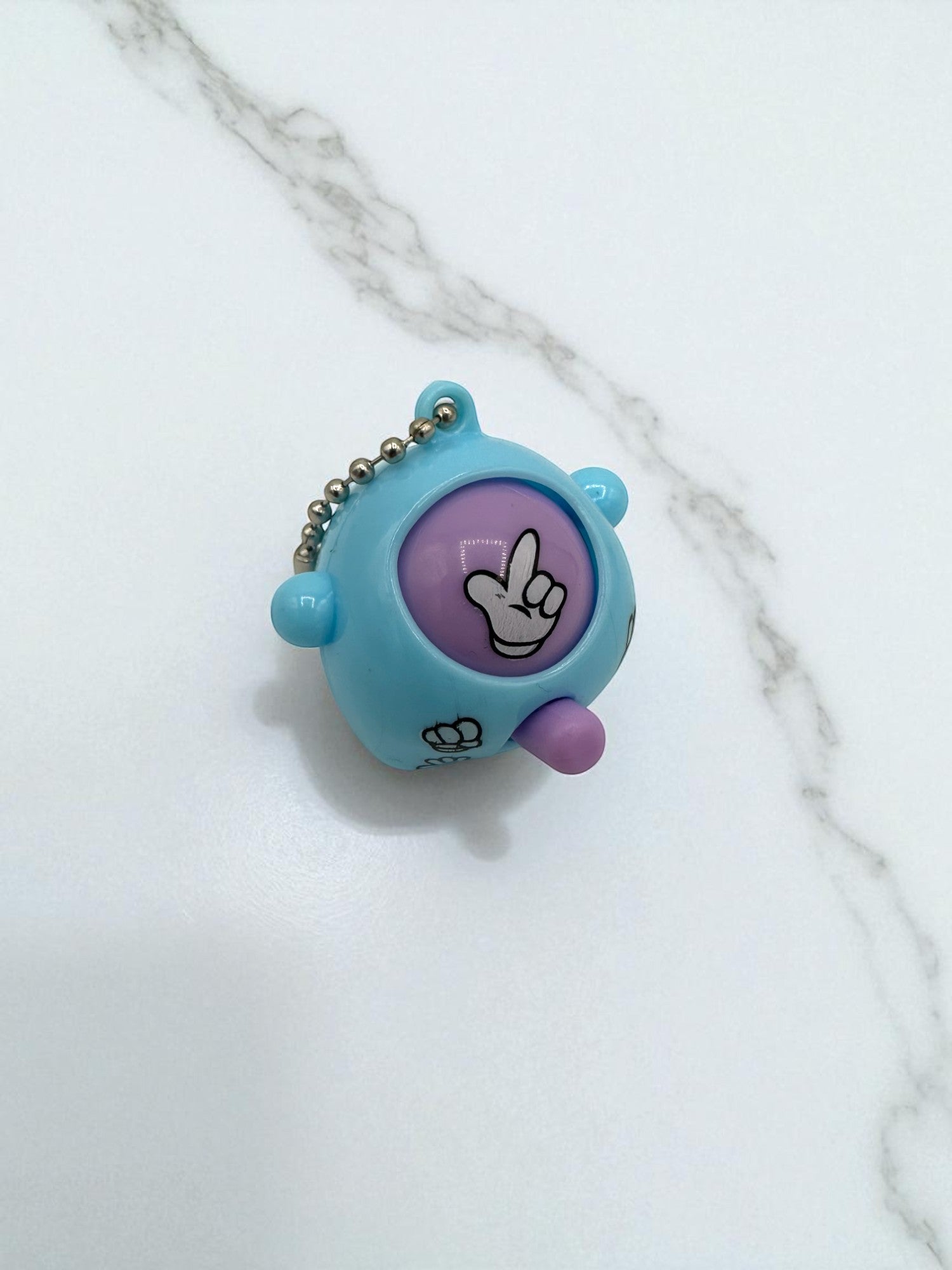 Sensitive Little Souls light blue plastic Rock-Paper-Scissors toy with purple display showing a hand gesture and a keychain.